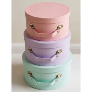 A stack of three vintage-inspired round travel hat boxes in pastel colors, perfect for protecting and organizing multiple hats during trips.