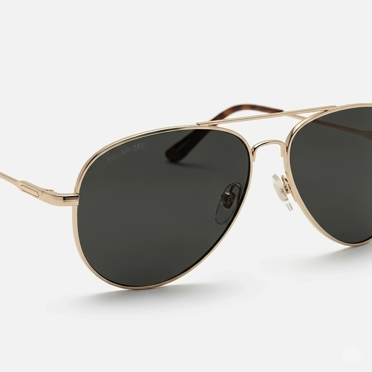 Close-up of classic aviator gold frame sunglasses with dark polarized lenses, perfect for a timeless and cool aesthetic.