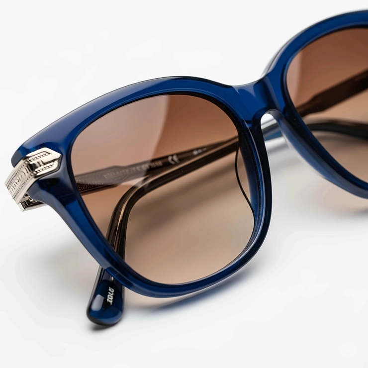 A close-up studio shot of a pair of high-quality blue women's sunglasses with a polished frame and tinted lenses.