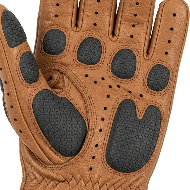 A detailed image of the palm of the driving glove, showing the non-slip grip pads and perforated holes for breathability, features essential for comfort and functionality while driving.