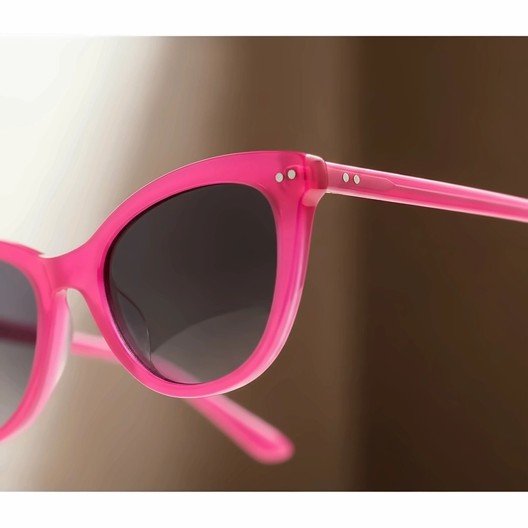 Close-up of hot pink sunglasses with a subtle cat-eye frame, highlighting the vibrant color and sleek design.