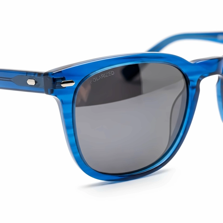 A close-up shot of a pair of stylish blue frame sunglasses with polarized lenses, showcasing the unique design details.