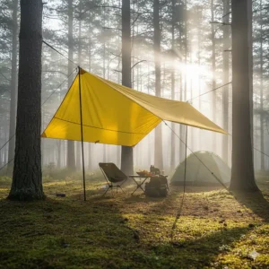 A bright yellow tarp is pitched high between two trees, providing a spacious, shaded area to relax outside of a tent.
