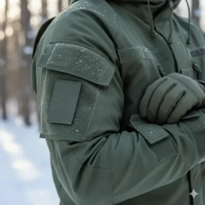 Detail of the velcro arm patches and adjustable cuffs on a foliage green army cold weather jacket.