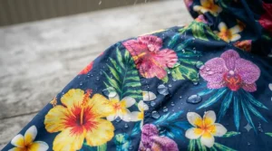 Close-up showing water beading off the fabric of a floral rain jacket for women.