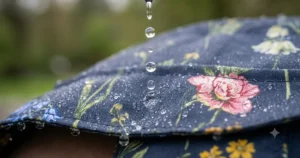 Macro shot showing the high-quality, breathable fabric texture of a women's floral rain jacket.