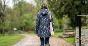 Full back view of a lightweight floral rain jacket for women, highlighting the tailored fit.