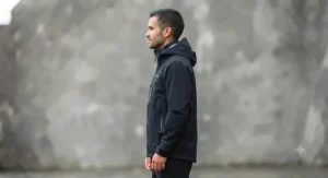 Side profile of black rain jacket showing adjustable cuffs