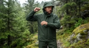 A man demonstrating the adjustable hood on a hooded rain suit men complete set with matching waterproof pants.